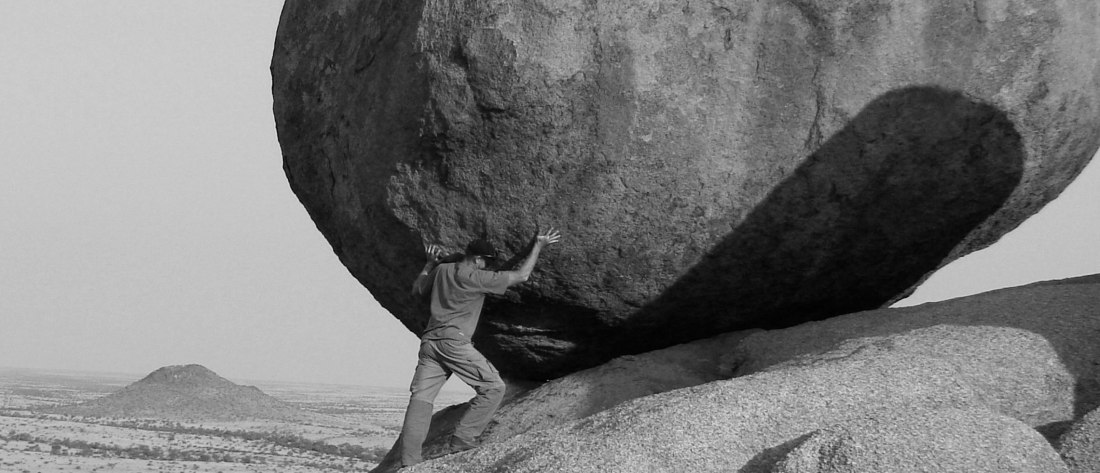 Man pushing a boulder, when God gives you more than you can handle